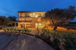A two-story building with a balcony on the upper floor, a covered entrance, and a stone facade. - House Srica (Sveti Filip i Jakov)