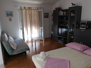 A bedroom with a bed, a chair, a wardrobe, and a bookshelf. - Apartment Ivica (Dugi Rat)