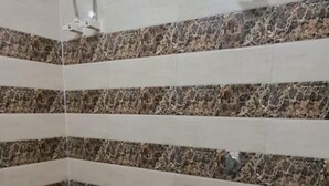 Un bagno con pareti rivestite di piastrelle a righe, un water, un lavandino e un catino.