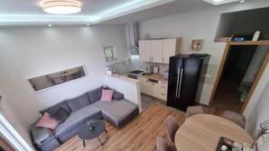 Ein zeitgemäßer Wohnraum mit Sofa, Esstisch und Küchenzeile.