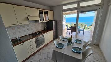Une cuisine avec un coin repas donnant sur la mer.