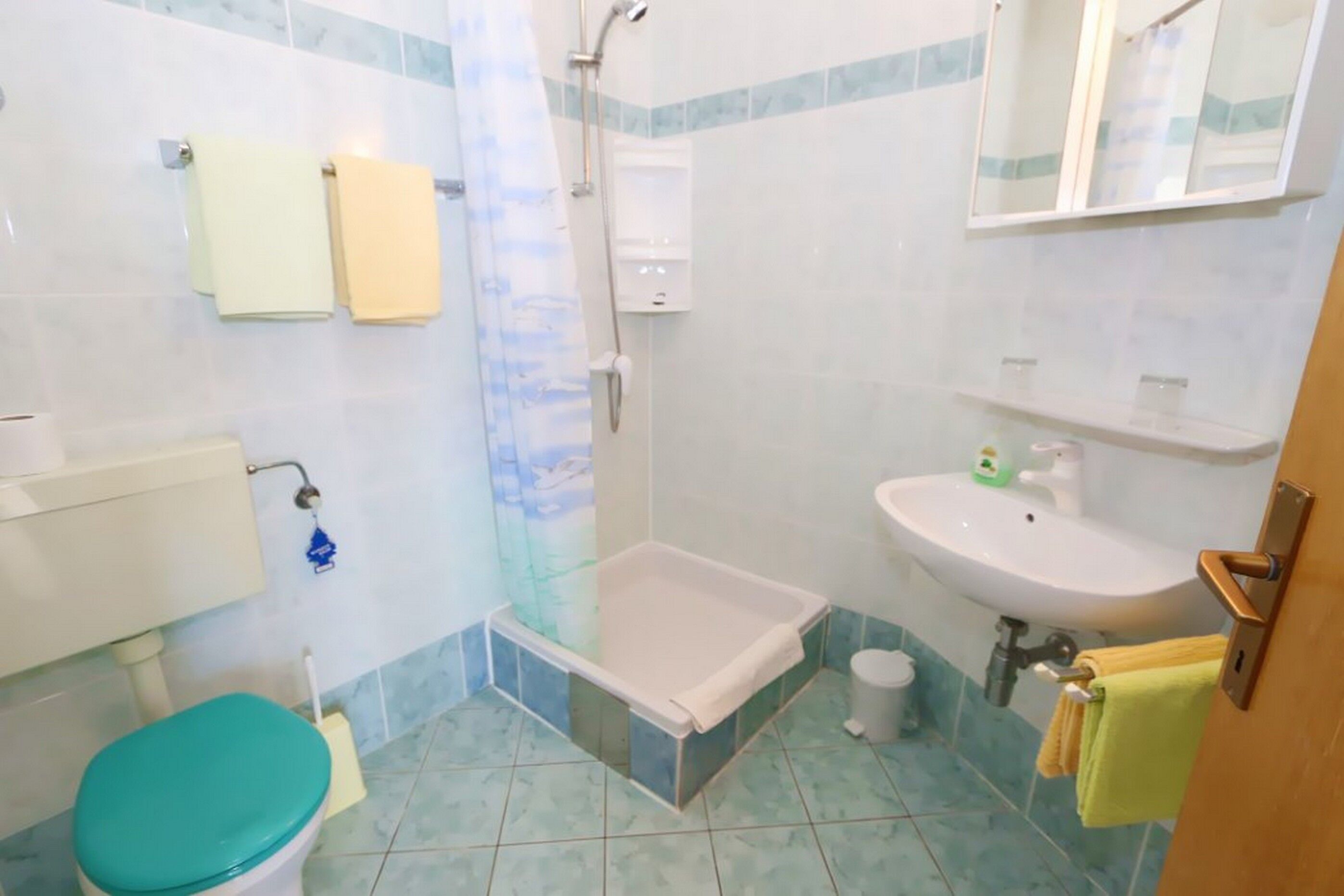 A bathroom with a toilet, bathtub, sink, and shower.
