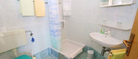 A bathroom with a toilet, bathtub, sink, and shower.
