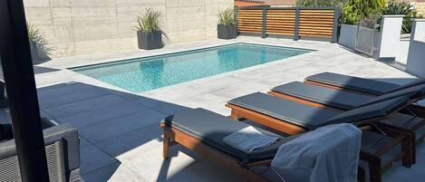 حمّام سباحة خارجي، مظلات على حمّام السباحة، مقاعد للتشمس