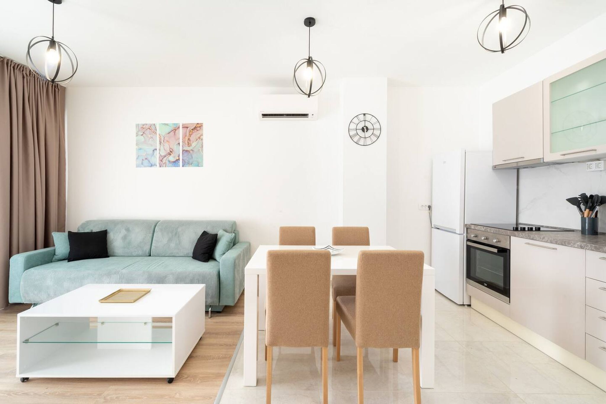 A modern living room with a sofa, a dining table with chairs, a coffee table, and a kitchen area with cabinets and appliances.