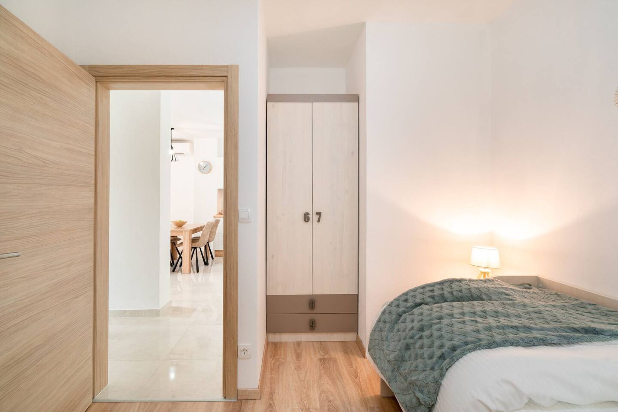 Ein Schlafzimmer mit Bett, Kleiderschrank und Schreibtisch mit Stuhl.