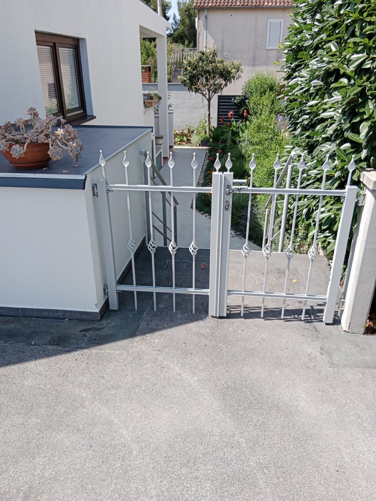 Ein Gebäude mit einem begrenzten Eingangsbereich und einem Blumentopf auf der linken Seite.