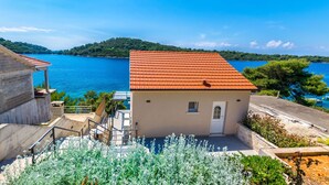 A coastal building with a red-tiled roof, a small porch, and a view of the sea. - House Paval (Blato)