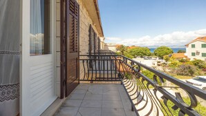 A balcony with a metal railing overlooking a residential area and a body of water. - Apartment Vinka (Supetar)