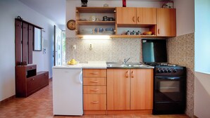 Una cocina compacta con armarios de madera, horno empotrado y refrigerador.