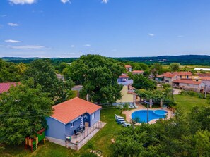 A residential area with a swimming pool, a children's play area, and houses with red roofs. - House Nina (Pazin)