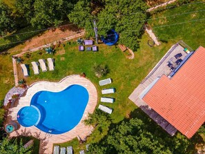 An aerial view of a property with a swimming pool, lounge chairs, and a red-roofed building. - House Nina (Pazin)