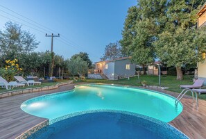 Piscina all'aperto, una piscina a sfioro, ombrelloni da piscina, lettini