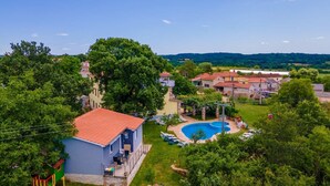 Una zona residenziale con piscina, area giochi e case con tetti in tegole rosse.