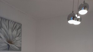 Ein modernes Schlafzimmer mit einem Bett, einer Nachttischschublade und einer Wandleuchte.