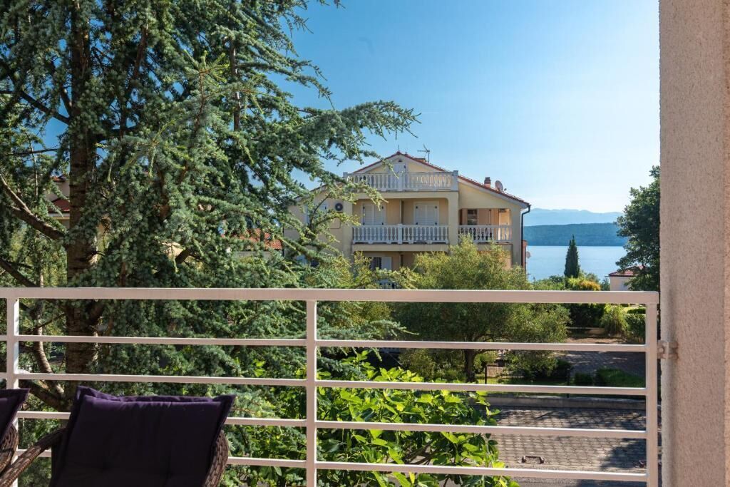 A balcony with a view of a building and a lake.