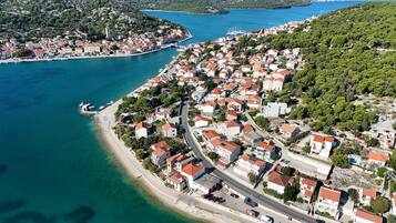 An aerial view of a coastal town with buildings, roads, and a beach.