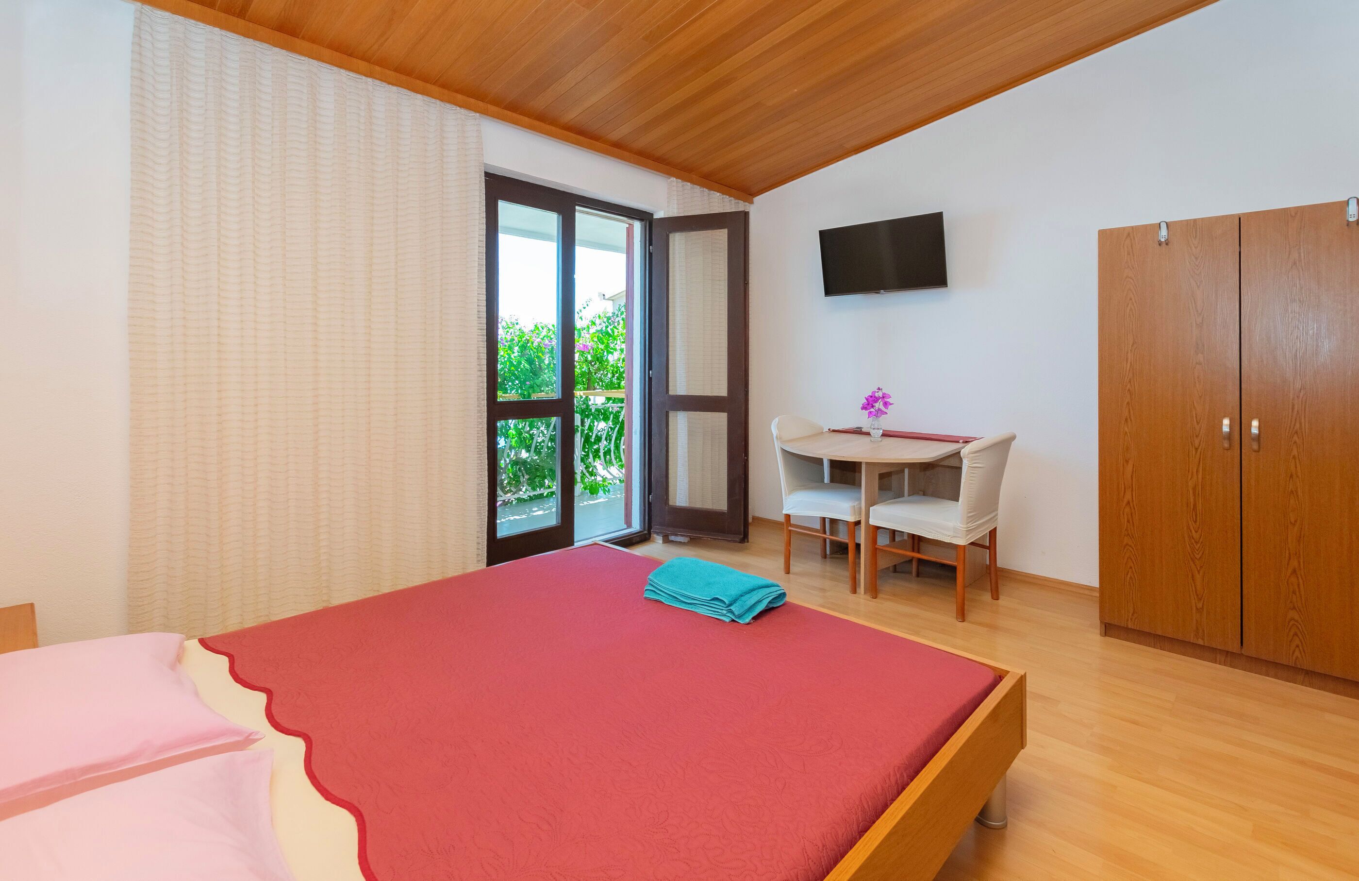 A bedroom with a bed, a desk, a chair, and a wardrobe.