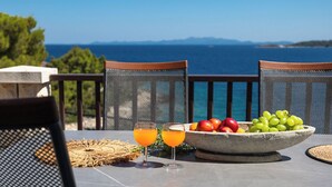 A table with fruit and drinks, overlooking a scenic view of the sea and mountains. - Apartments Doro (Blato)