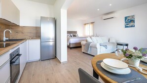 A compact apartment with a kitchenette, a dining area, and a living space. - Apartments Doro (Blato)