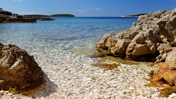 A rocky shoreline with clear water and distant land. - Apartments Doro (Blato)