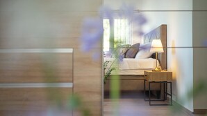 A modern bedroom with a bed, bedside table, and lamp. - Apartments Doro (Blato)