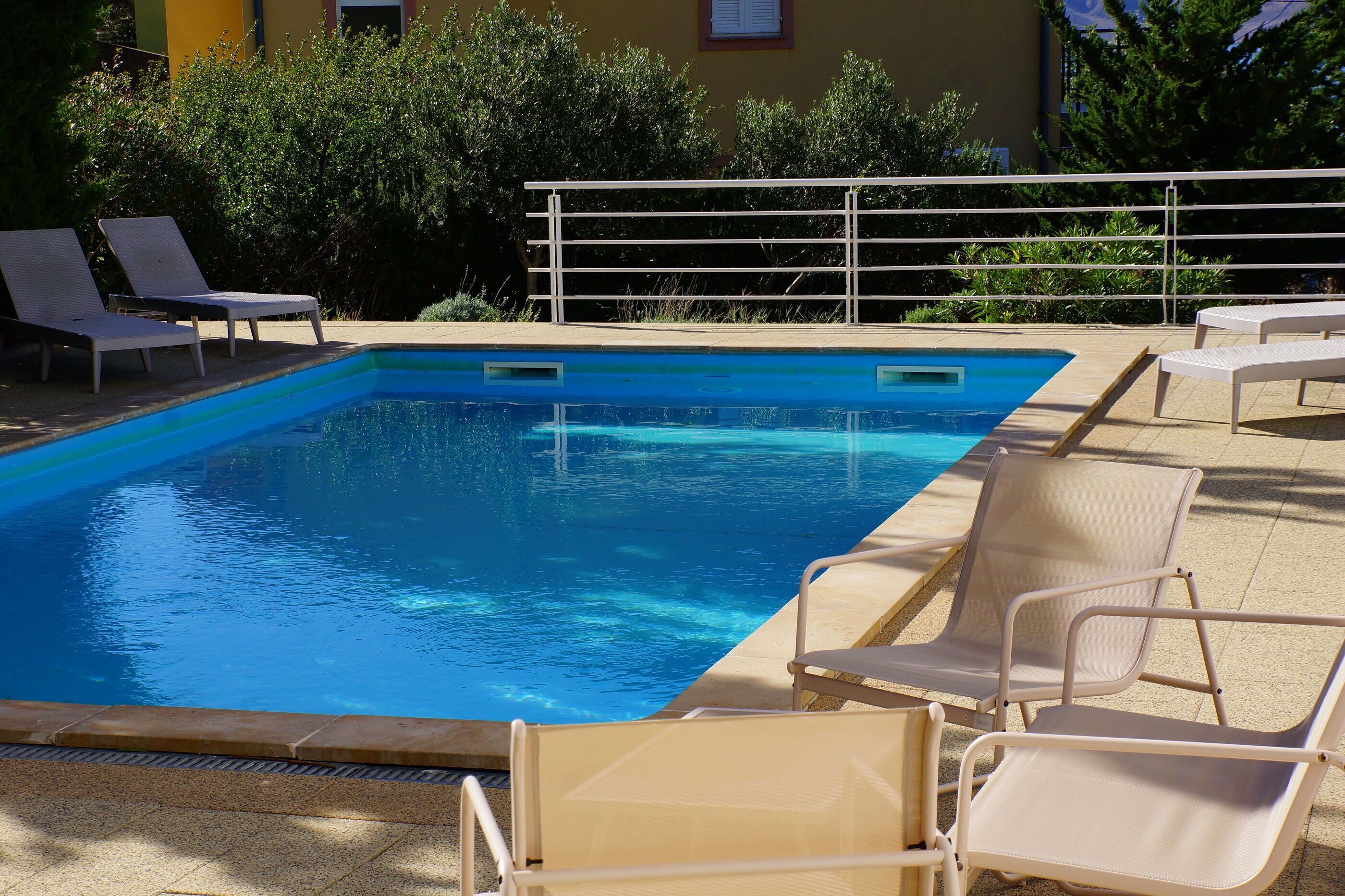 Una piscina al aire libre, tumbonas
