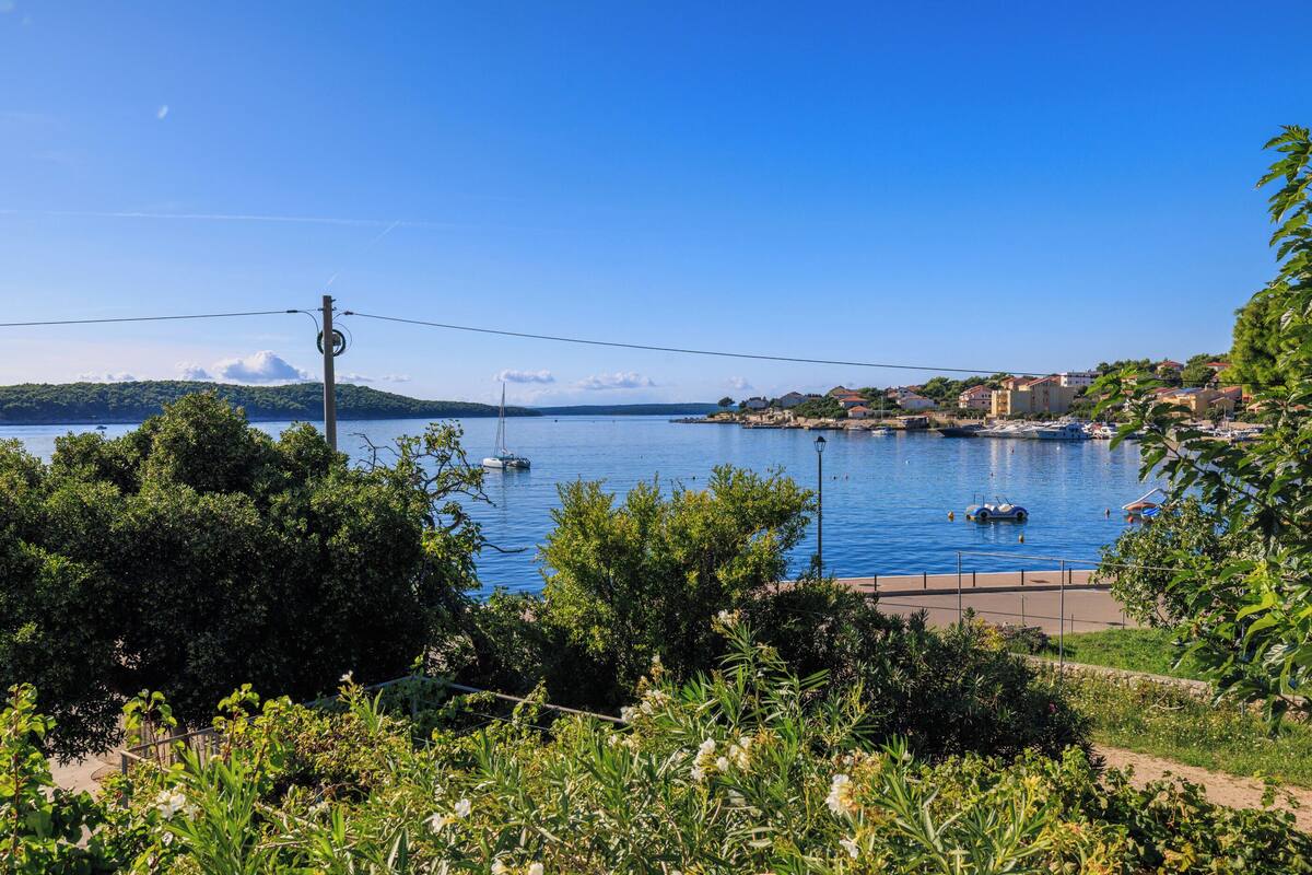 Une ville côtière dotée d’un port de plaisance, de bateaux et d’un ciel bleu azur.