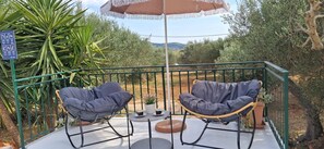 A balcony with two cushioned chairs, a small table, and a potted plant. - House Darin Dvor (Vela Luka)