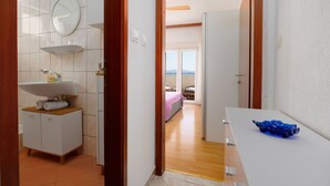 Une salle de bain équipée d’un lavabo, d’un miroir et d’un porte-serviettes.