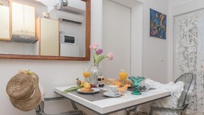 Una mesa de desayuno con un florero, una cesta y alimentos para el desayuno.