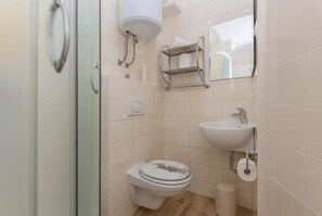 Un baño con inodoro, lavabo y perchero para toallas.