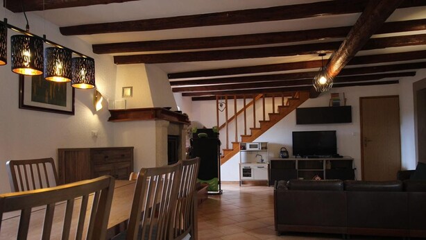 Una sala de estar amplia con comedor, una escalera y una cocina.