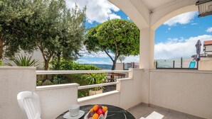 A balcony with a table, chairs, and a fruit bowl. - House Mimica (Omis)