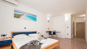 A bedroom with a bed, bedside table, desk, chair, and a painting on the wall. - House Mimica (Omis)
