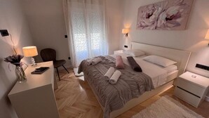 Une chambre moderne avec un grand lit, des tables de chevet, un bureau et une chaise.