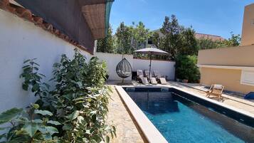 Outdoor pool, a heated pool, open open 24 hours a day, pool umbrellas