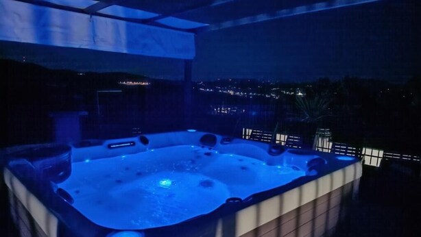 A hot tub with a view of the city at night. - House Nevenka (Omis)