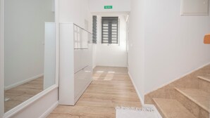 A narrow hallway with a wooden floor, white walls, and a door leading to a room. - House Nevenka (Omis)