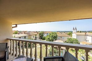 A balcony with a view of a residential area, including houses and a church. - Apartment Radosevic (Medulin)