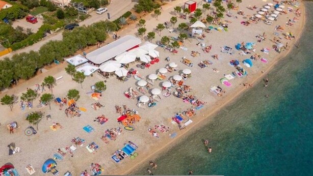 An aerial view of a beach with numerous umbrellas and people. - Apartment Pogi Srima (Vodice)