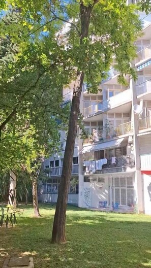 A multi-story residential building with balconies, a grassy courtyard, and trees. - Apartment Vesna (Split)