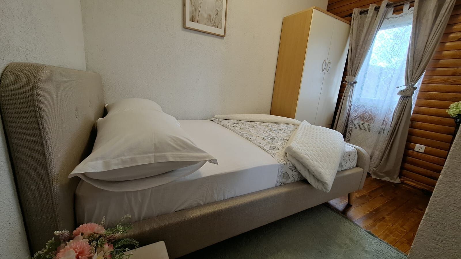 A single bed with a mattress, pillows, and a blanket.