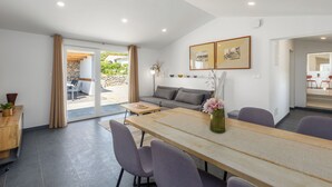 A modern interior with a dining area, sofa, and a view to the outside. - House Prenc (Sveti Petar u Sumi)