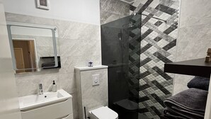 A modern bathroom with a shower, toilet, and sink. - Apartment Ivana (Makarska)
