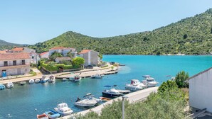 Uma marina com barcos atracados, rodeada por edifícios e colinas.