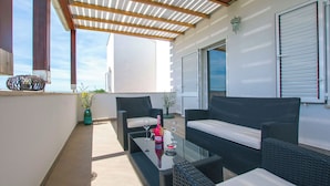 A balcony with wicker furniture, a glass table, and a bottle of champagne. - House Srecko (Polaca)