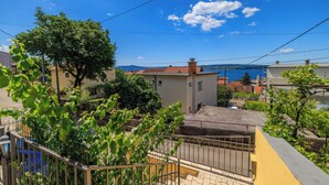 A residential area with a view of the sea, houses with red roofs, and greenery. - Apartment Car (Crikvenica)