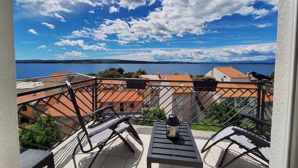 A balcony with a view of a lake and buildings. - Apartments Mar (Crikvenica)