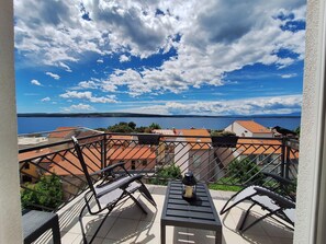 A balcony with a view of a lake and buildings. - Apartments Mar (Crikvenica)